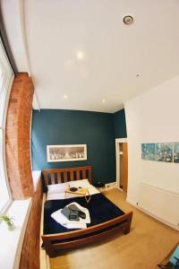 诺丁汉Lovely Studio Apartment in the Heart of Nottingham的一间卧室配有一张蓝色墙壁的床