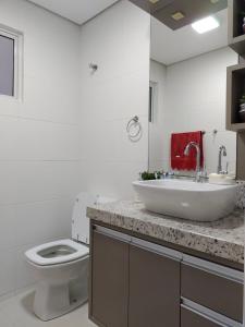 格拉瓦塔尔Apartamento Vida Boa的白色的浴室设有水槽和卫生间。