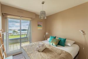 迪纳尔HEOL - appartement 2 chambres - vue mer et parking的一间卧室设有一张床,享有海景
