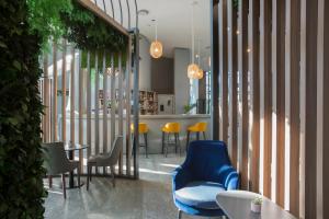 米兰voco Milan-Fiere, an IHG Hotel的餐厅设有蓝色椅子和桌椅