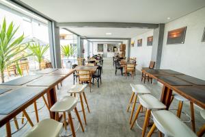 伯迪亚哥Cadiz Pousada e Lazer的餐厅设有木桌、椅子和窗户。