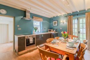 奇平卡姆登2 Manor Lodge Cottages的厨房以及带桌椅的用餐室。