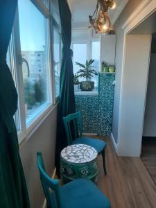 布泽乌Restauro Apartament的一间设有两把椅子、一张桌子和一个窗户的房间