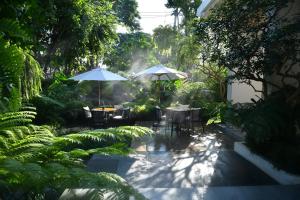 清迈Welladee Wellness Chiang Mai的花园内提供两把遮阳伞和桌椅