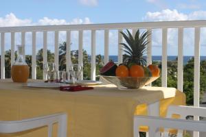 勒穆莱Résidence Tropicale的阳台上的桌子上放着一碗水果