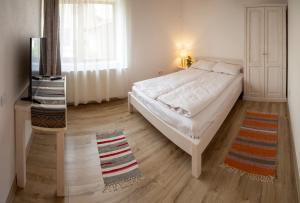 PrejmerOtto's Guesthouse的卧室配有白色的床和窗户。