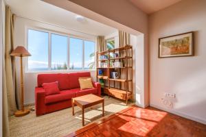 卡尼索Garajau House - Sunrise to Sunset Ocean View Villa的客厅配有红色沙发和书架
