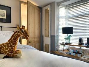 布莱顿霍夫27 Brighton Guesthouse的塞满长颈鹿坐在卧室的床上