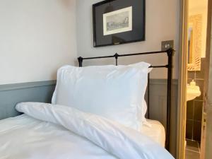 布莱顿霍夫27 Brighton Guesthouse的一张带白色枕头和镜子的床