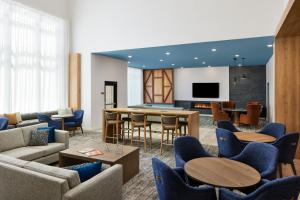 奥本Staybridge Suites - Auburn - University Area, an IHG Hotel的带沙发和桌子及电视的客厅