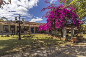 帕苏斯工程师镇Resort Fazenda 3 Pinheiros的一座有紫色花的树的建筑