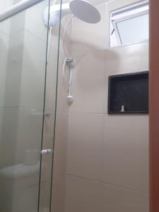 嘎林海斯港Studio Moah 205_Porto de Galinhas的浴室设有玻璃门淋浴和电视