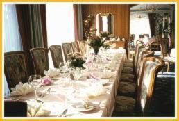 格斯韦因斯泰因克朗酒店的餐厅里一张长桌,配有白色的桌椅