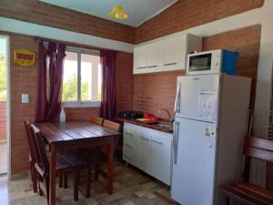 库拉布罗切罗镇Departamentos Las Marias的厨房配有白色冰箱和木桌