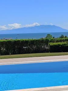 亚历山德鲁波利斯Villa Belvedere的蓝色的游泳池,背景是大海