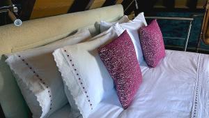 卡马查Casas de Pedra的床上的三个枕头,配有粉色和白色枕头
