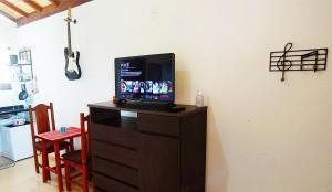 卡兰卡斯Toca dos Coelhos Chalés的房间里的梳妆台上方的电视机