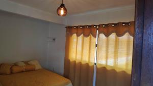 安格拉杜斯雷斯Flat com portão na Praia的一间卧室配有床和带窗帘的窗户