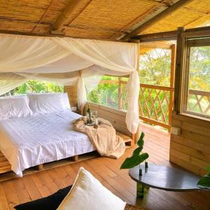 卡利San Andrés, Hermosa Cabaña Privada en Reserva Natural - Cali Valle del Cauca的一间卧室,在木甲板上配有一张床