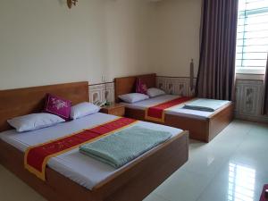 Bắc GiangKhách Sạn Hương Sơn的两张床位于带窗户的房间内