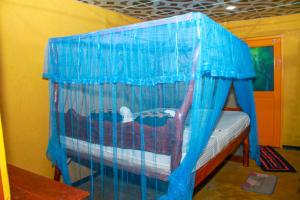 锡吉里亚Relax Nature Villa的蓝色蚊帐的房间里一张床位