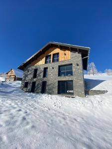 DoucyCHALET CONFIDENTIEL VALMOREL - Chalet de Haut de Gamme 4 étoiles 12 personnes的雪地中的建筑物,雪地中的脚印