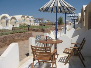 达哈布Lagona Dahab Hotel的庭院里配有桌椅和遮阳伞