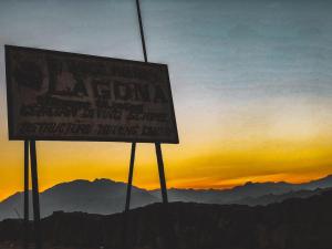 达哈布Lagona Dahab Hotel的日落时山顶上的标志