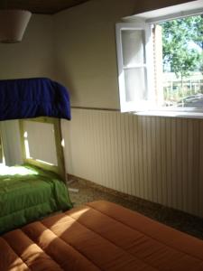 圣拉斐尔香提旅舍的一间卧室配有一张带窗户的床和床罩