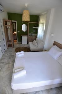 托罗尼Haus Risos Next Generation的卧室配有一张白色的大床和一张沙发。