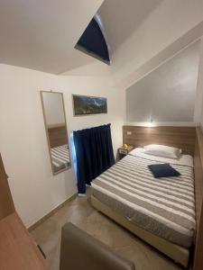 米兰蒙特卡洛酒店的一间卧室配有一张大床和镜子