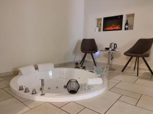 塔兰托Lux Suite的带浴缸的客房,配有两把椅子和电视