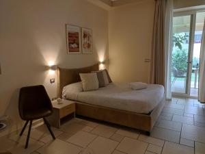 塔兰托Lux Suite的卧室配有床、椅子和窗户。