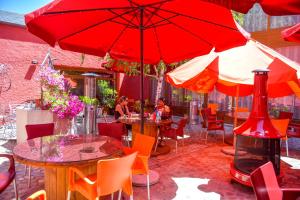 洛索亚CicloLodge的一个带桌椅和红色遮阳伞的庭院