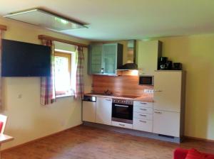 纽科琴格罗斯夫艾斯霍阿玛特公寓的厨房配有白色橱柜和白色冰箱。