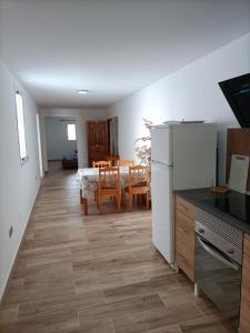 维辛达里奥Apartment Taliarte 36的厨房以及带桌子和冰箱的用餐室