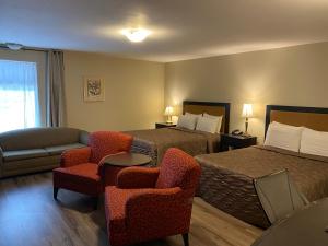 魁北克市蒙特克里斯托套房酒店的酒店客房带两张床、一张沙发和椅子。