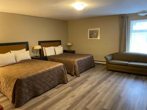 魁北克市蒙特克里斯托套房酒店的酒店客房,配有两张床和椅子