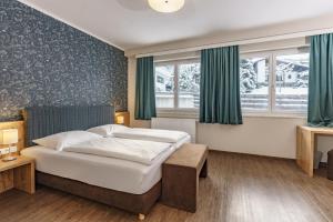 斯拉德明Appartements Landhaus Hubertus Wellness & Breakfast的酒店客房设有一张床和两个窗户。