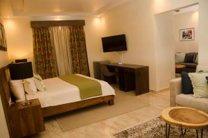 拉罗马纳Halibut Hotel的一间卧室配有一张床、一台电视和一张沙发