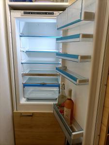 卢森堡Superb City Apartement/studio的装有一瓶液体的开放式冰箱