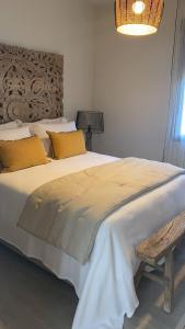 哈维亚3 Bedroom piso in El pueblo de Javea的卧室配有一张带黄色枕头的大型白色床。