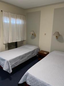 圣米格尔·德·图库玛Hotel Miami的酒店客房设有两张床和窗户。
