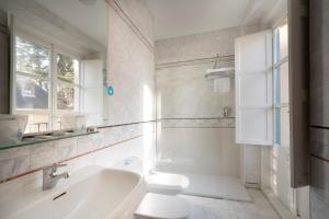 圣洛伦索-德埃斯科里亚尔米兰达与苏卓酒店的白色的浴室设有卫生间和水槽。