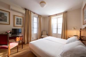 圣洛伦索-德埃斯科里亚尔米兰达与苏卓酒店的一间卧室配有一张床和一张书桌及电视