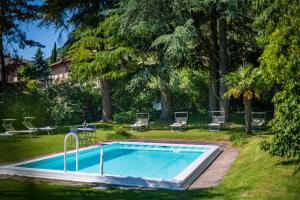 泰尔梅诺 金葡萄酒店的一座树木繁茂的庭院内的游泳池