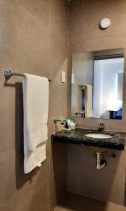 罗萨里奥Hotel Musto的一间带水槽和镜子的浴室
