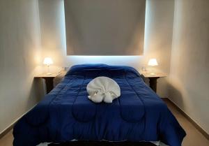 罗萨里奥Hotel Musto的一张蓝色的床,上面有白色枕头