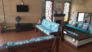 卡拉瓜塔图巴Santa Paula - Cocanha - De frente para a Praia的客厅配有两张沙发和一台电视
