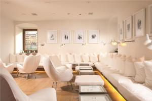 佛罗伦萨Hotel Continentale - Lungarno Collection的一间设有白色椅子和桌子的等候室